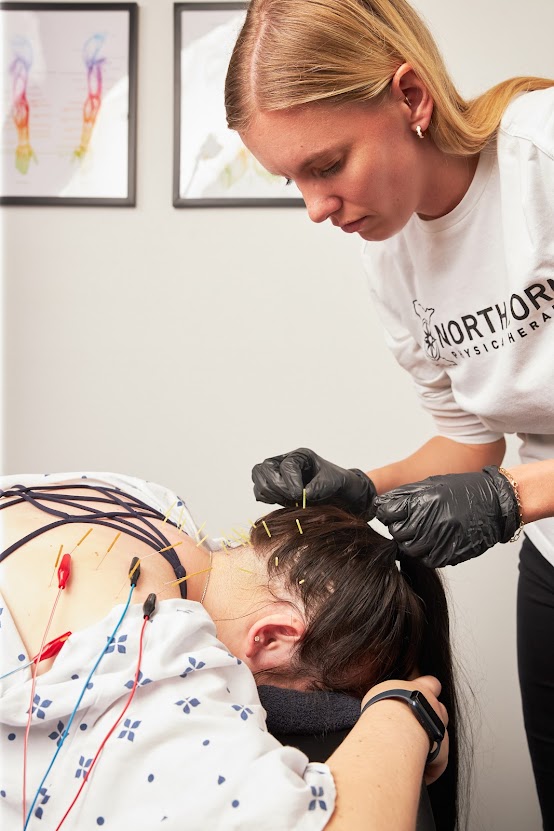 Julia Nelson, DPT, performs dry needling on a patient's neck and scalp.